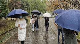 雨中许多人撑着伞 描述已自动生成